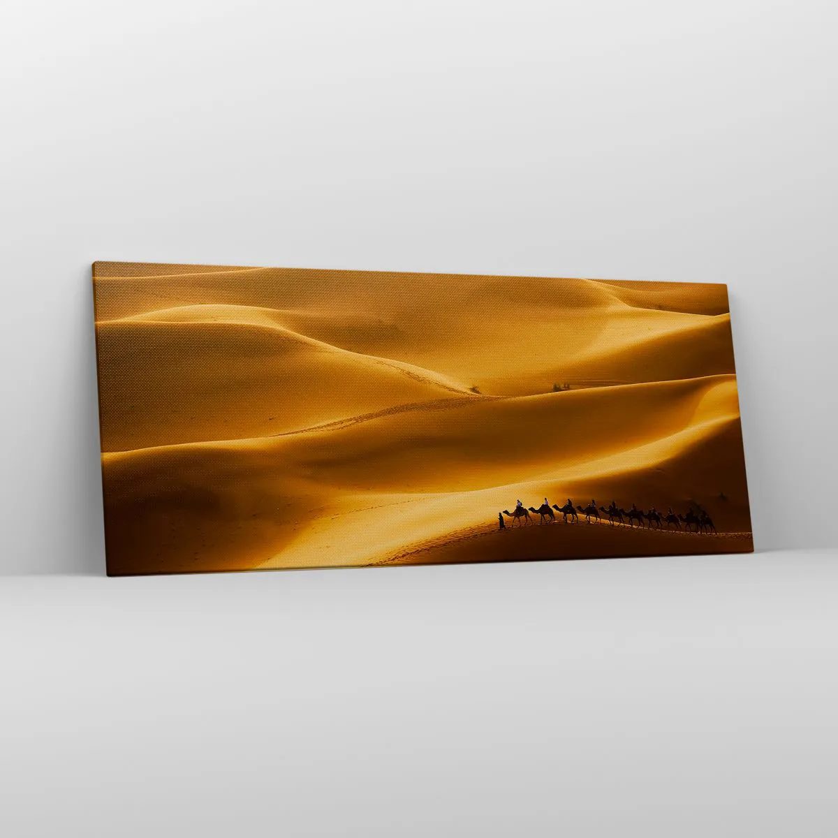 Bild auf Leinwand - Leinwandbild - Eine Karawane von Kamelen wandert durch die goldenen Dünen der Wüste. - 120x50cm - Wohnwagen in den Wüstenwellen - Moderne Wanddekoration für Wohnzimmer und Schlafzimmer ARTTOR
