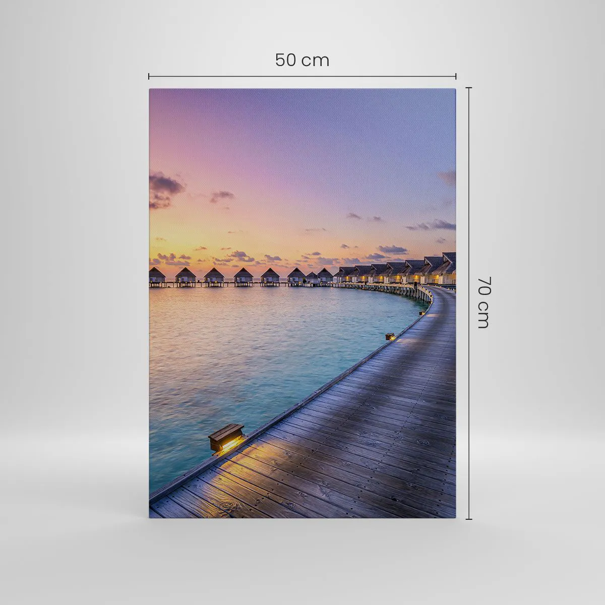 Obraz na płótnie - Tropikalne domki na wodzie o zachodzie słońca - 50x70cm - Wakacje - powrót do źródeł - Nowoczesna dekoracja ścienna do salonu, kuchni i sypialni ARTTOR