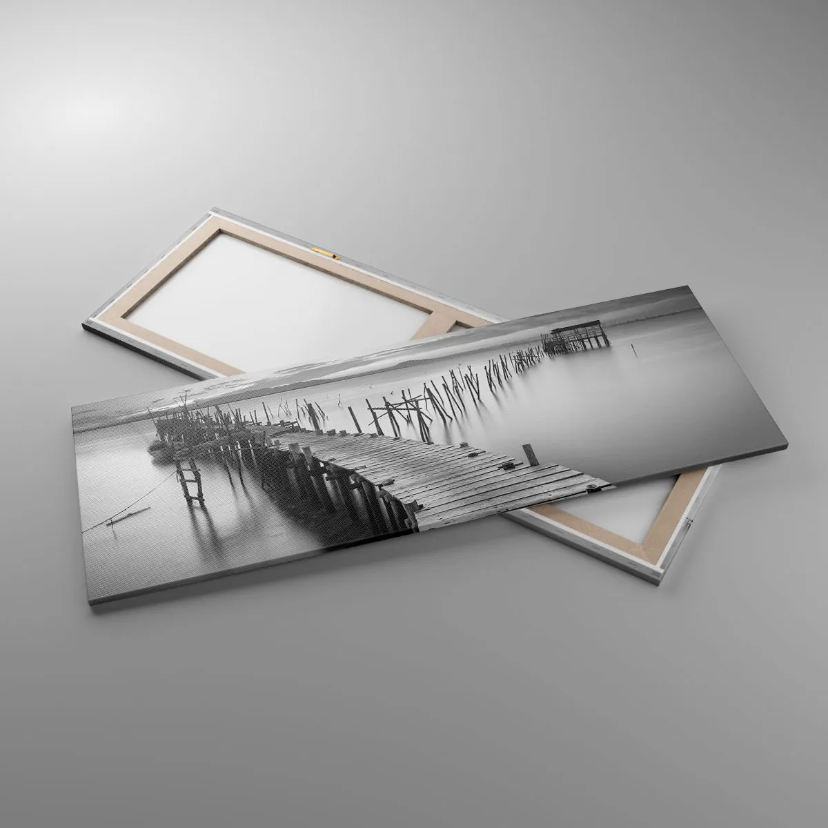 Obraz na płótnie - Drewniany pomost na spokojnym jeziorze w odcieniach szarości - 140x50cm - Spokój zapomnianego brzegu - Nowoczesna dekoracja ścienna do salonu i sypialni ARTTOR