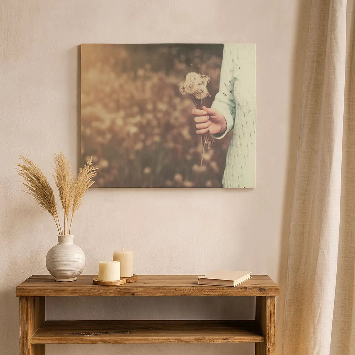 Canvastavla - Bild på duk - En hand som håller maskrosor mot en suddig bakgrund av ett fält fullt av blommor. - 70x50cm - Behåll dem - Modern väggdekoration för vardagsrum och sovrum ARTTOR