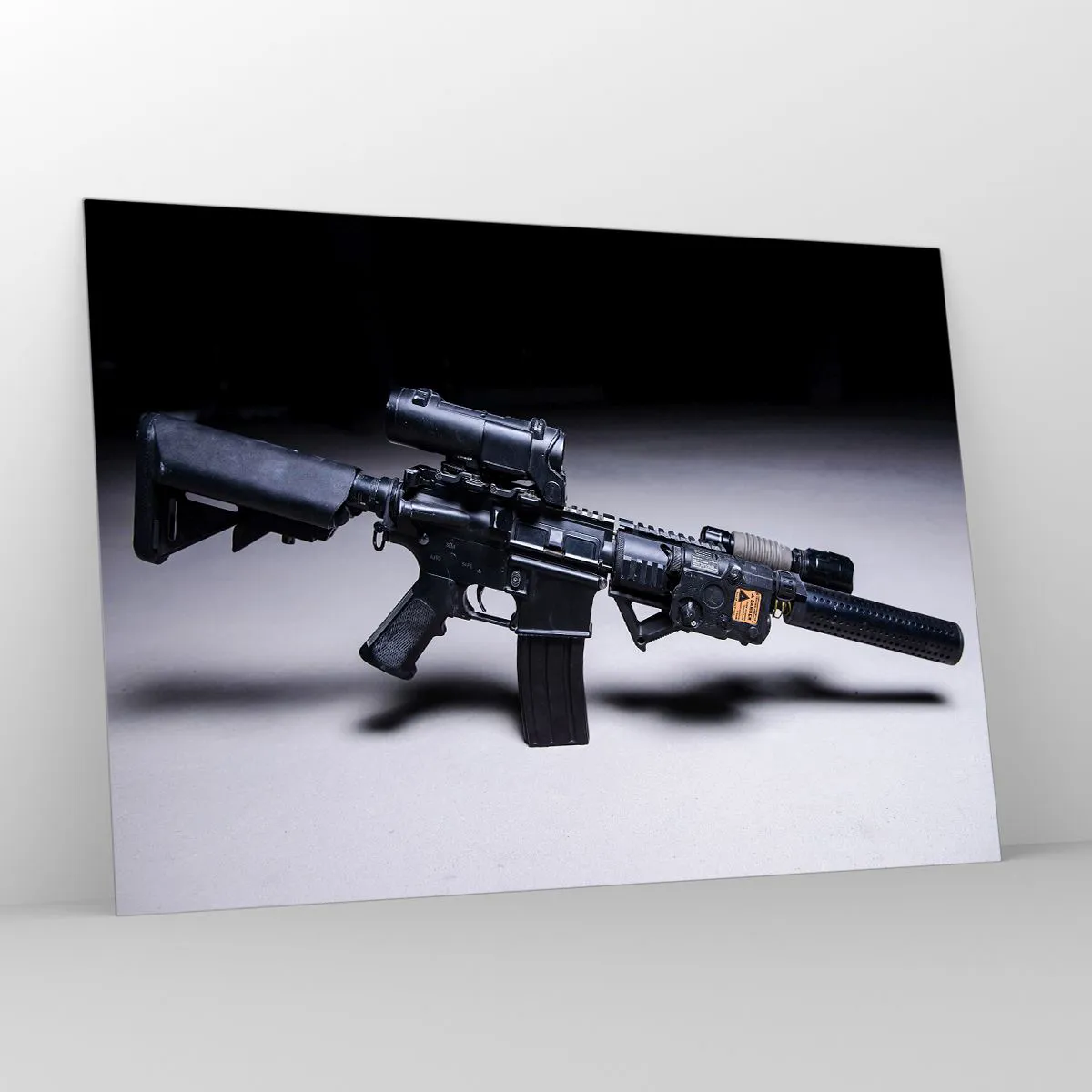 Obraz na szkle - Czarny karabin szturmowy z osprzętem leżący na jasnym tle - 100x70cm - Mroczny rycerz - Nowoczesna dekoracja ścienna do salonu, kuchni i sypialni ARTTOR