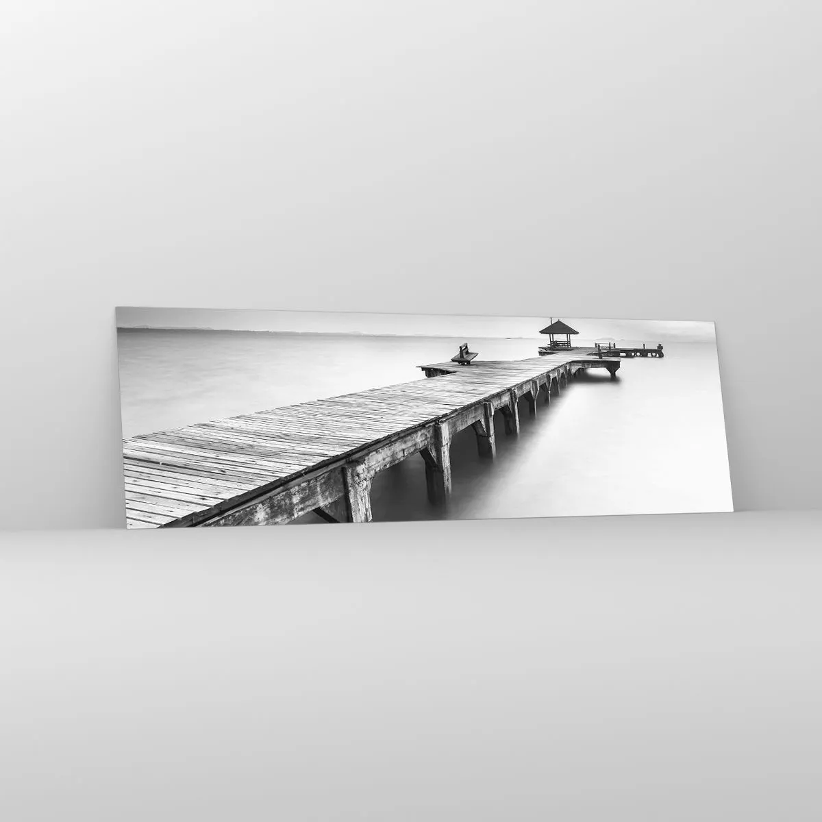 Glasbild - Bild auf glas - Eine Schwarzweißansicht eines Holzstegs über ruhigem Wasser. - 160x50cm - In die Ferne - Moderne Wanddekoration für Wohnzimmer und Schlafzimmer ARTTOR