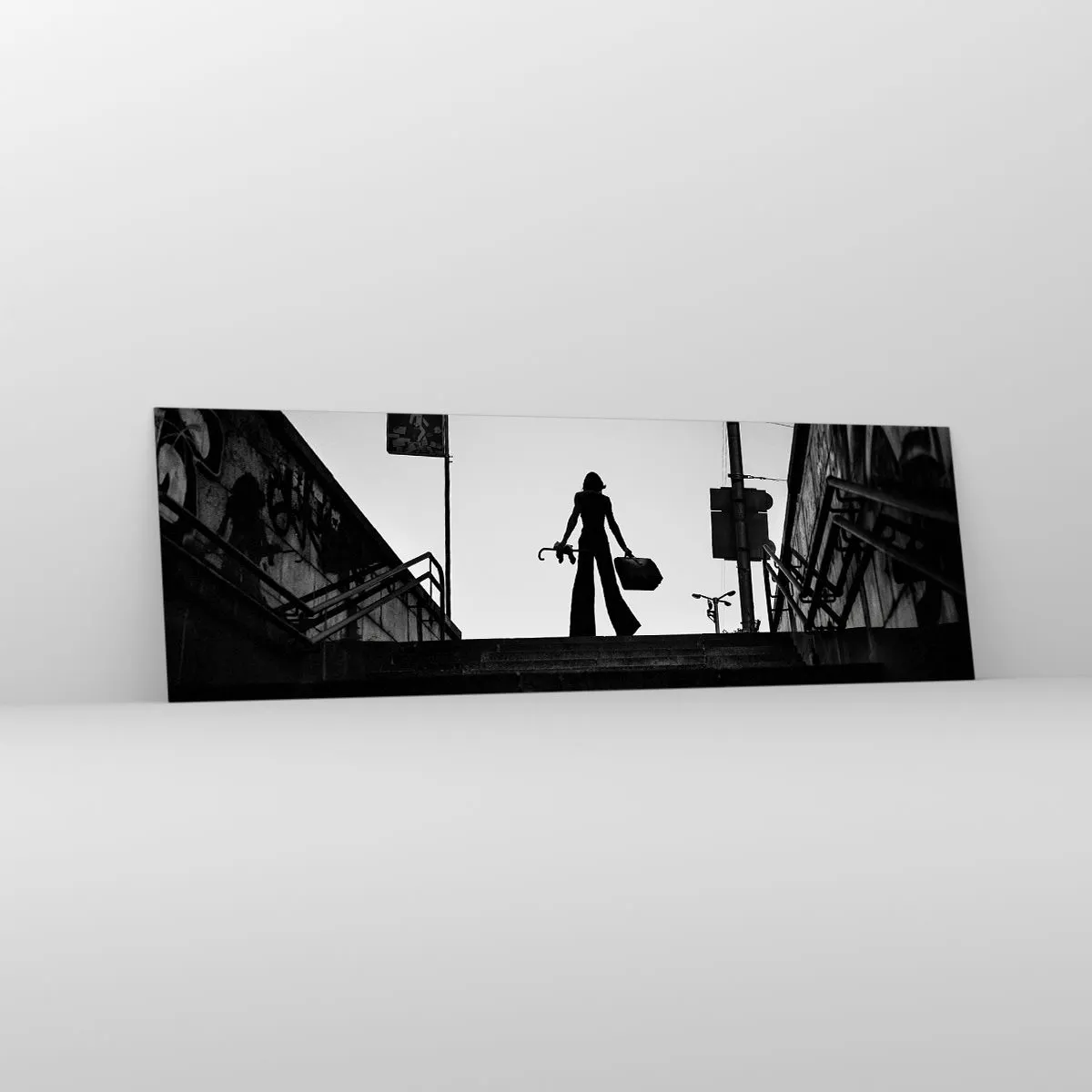 Glasbild - Bild auf glas - Eine Frauenfigur auf der Treppe in Schwarzweiß mit dynamischer Atmosphäre - 160x50cm - Städtisches Wandern - Moderne Wanddekoration für Wohnzimmer und Schlafzimmer ARTTOR