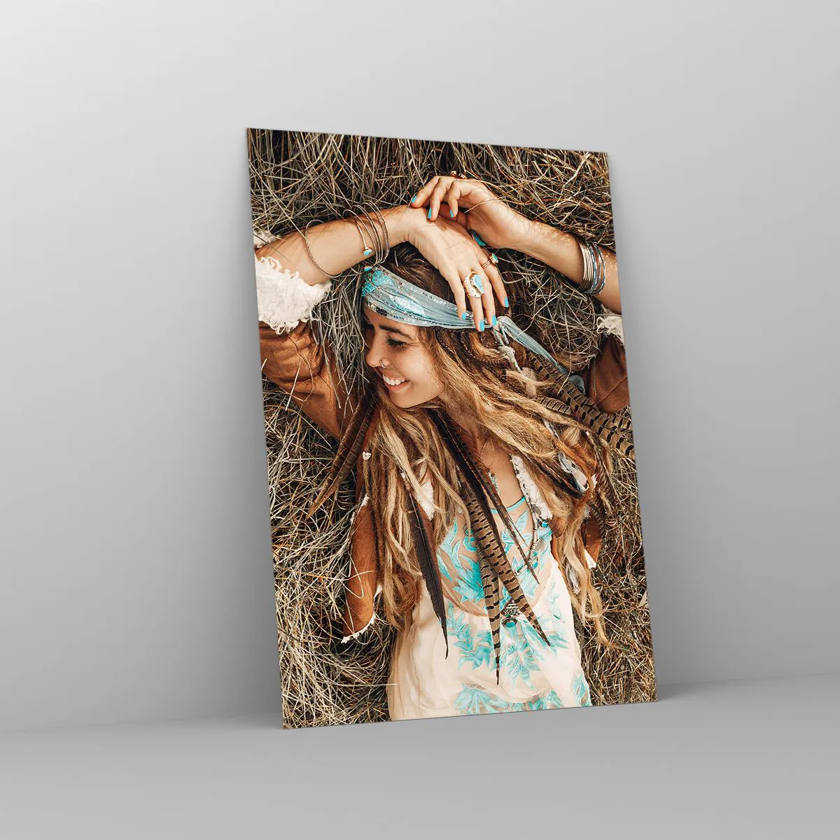Obraz na szkle - Kobieta w stylu boho leżąca na sianie - 70x100cm - W drodze do lata miłości - Nowoczesna dekoracja ścienna do salonu i sypialni ARTTOR