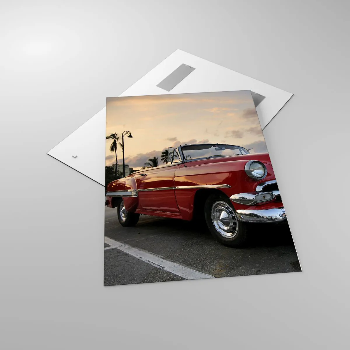 Obraz na szkle - Czerwony klasyczny kabriolet zaparkowany przy palmach o zmierzchu - 70x100cm - Czerwony żar tropików - Nowoczesna dekoracja ścienna do salonu i sypialni ARTTOR