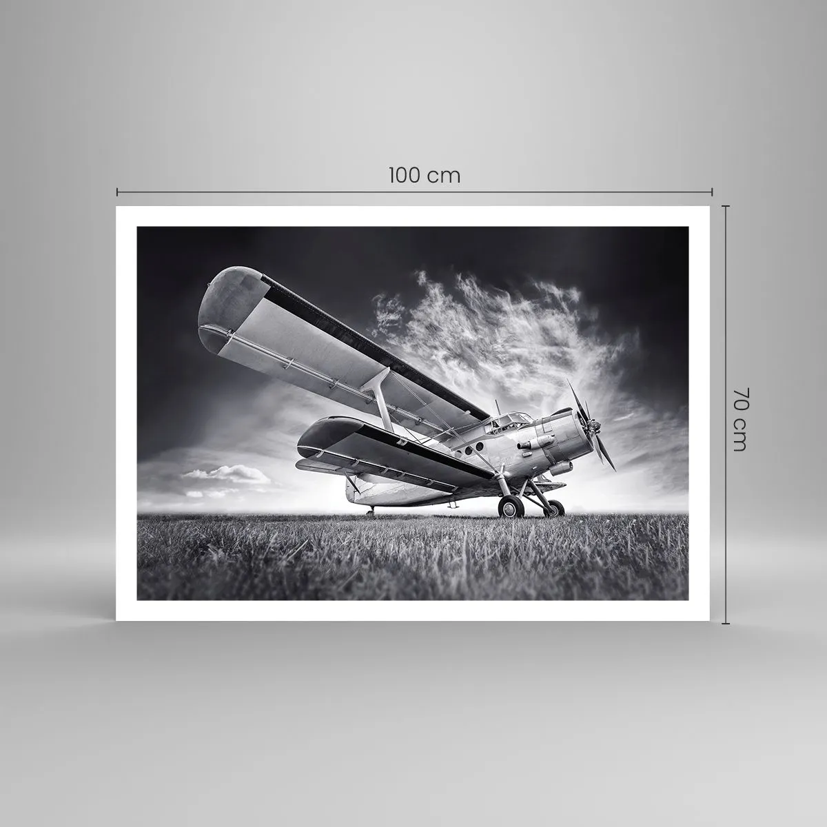 Poster - Un aereo contro un cielo drammatico in bianco e nero - 100x70cm - Giramondo alato - Decorazione murale moderna per soggiorno e camera da letto ARTTOR