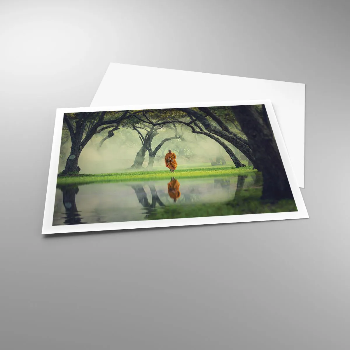 Plakat - Mnich w pomarańczowej szacie w lesie z mglistym tłem i odbiciem w wodzie - 100x70cm - W drodze do oświecenia - Nowoczesna dekoracja ścienna do salonu i sypialni ARTTOR